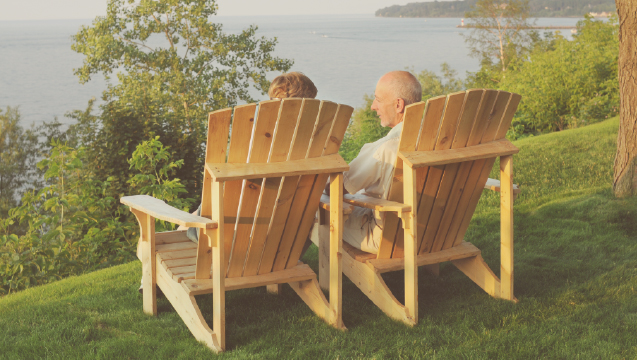 A senior man and woman enjoy the view by a lake.