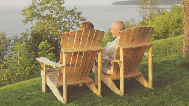 A senior man and woman enjoy the view by a lake.